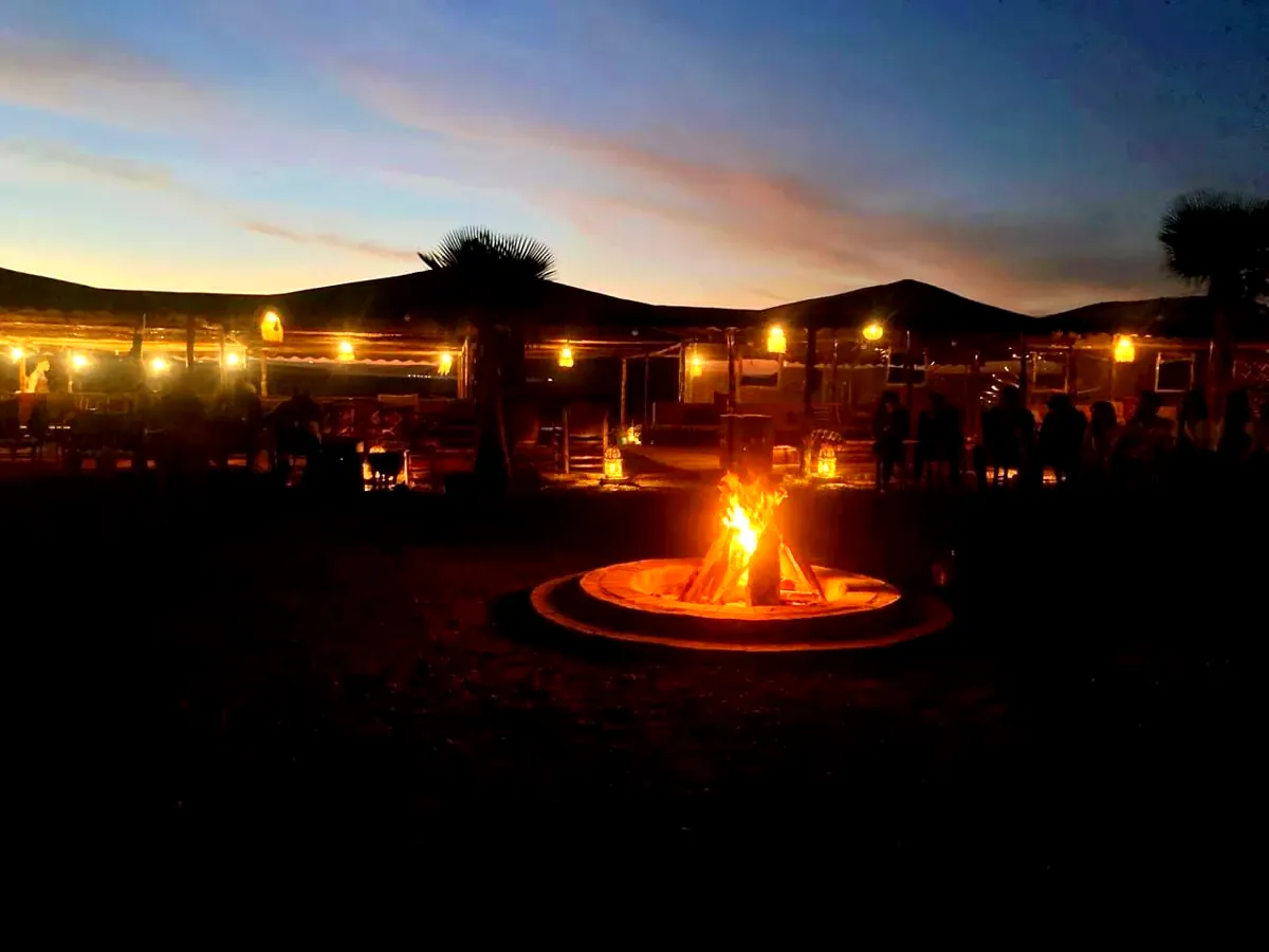 Feu de camp au coucher du soleil au campement d'Agafay, près de Marrakech